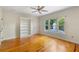 Bedroom with hardwood floors, a built-in bookshelf, and a large window overlooking the backyard at 408 W Pearl St, Minneola, FL 34715