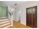 Inviting entryway featuring wood floors, a staircase, and a wood door with glass panes at 408 W Pearl St, Minneola, FL 34715