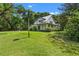 Charming two-story home with white siding, metal roof, wrap-around porch, and lush landscaping at 408 W Pearl St, Minneola, FL 34715