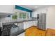 Modern kitchen features white cabinets, stainless steel appliances, subway tile backsplash, and hardwood floors at 408 W Pearl St, Minneola, FL 34715