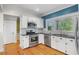 Kitchen offers white cabinets, granite countertops, stainless appliances, and hardwood floors at 408 W Pearl St, Minneola, FL 34715