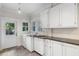 Bright laundry room with white cabinets, dark countertops and tile floors at 408 W Pearl St, Minneola, FL 34715