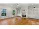 Cozy living room featuring hardwood floors, built-in shelves, and a marble fireplace at 408 W Pearl St, Minneola, FL 34715