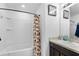 Well-lit bathroom features a shower-tub combination and a dark wood vanity with a granite countertop at 411 Ridges Dr, Dundee, FL 33838