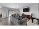 Spacious living room with tile flooring, a sliding glass door, and a mounted television at 411 Ridges Dr, Dundee, FL 33838