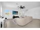 Bright living room featuring a large sectional sofa, entertainment center, and a ceiling fan at 4432 Desert Rose Ave, Kissimmee, FL 34746