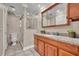 Bathroom featuring granite countertops, framed mirror, and glass door shower at 463 Warrenton Rd # 463, Winter Park, FL 32792