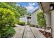 Villa showing walkway to an outdoor storage building and surrounding trees at 463 Warrenton Rd # 463, Winter Park, FL 32792