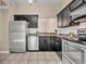 Kitchen with stainless steel appliances, black cabinetry, and tiled floor at 463 Warrenton Rd # 463, Winter Park, FL 32792