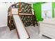 Bedroom with bunk bed, slide, carpeted floor, green accent wall and white furniture at 4912 Windermere Ave, Kissimmee, FL 34746