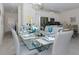 Open-concept dining area with a glass table, modern chairs, and stylish place settings, seamlessly connecting to the kitchen at 4912 Windermere Ave, Kissimmee, FL 34746