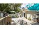Outdoor back deck featuring outdoor seating, a dining area, vibrant rugs, and lush landscaping for a relaxing experience at 5177 Chesapeake Ave, Orlando, FL 32808