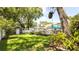 Spacious backyard featuring a deck, storage shed, mature trees, and lush landscaping at 5177 Chesapeake Ave, Orlando, FL 32808
