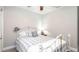 Bright bedroom featuring neutral walls, a white metal bed frame, and a plush throw pillow with the words 