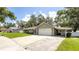 Home offers a two-car garage and carport, plus ample driveway space and lush lawn in a desirable neighborhood at 5177 Chesapeake Ave, Orlando, FL 32808