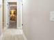 Hallway featuring wood-look tile flooring and a view into a bedroom with wood paneling and carpet at 5177 Chesapeake Ave, Orlando, FL 32808