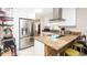 Modern kitchen features stainless steel refrigerator and an island with wooden paneling and granite countertops at 5177 Chesapeake Ave, Orlando, FL 32808