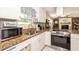 Well-lit kitchen featuring granite countertops, white cabinetry, stainless steel oven, and modern appliances at 5177 Chesapeake Ave, Orlando, FL 32808