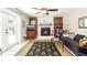Cozy living room with a fireplace, ceiling fan, patterned rug, and access to the outdoors at 5177 Chesapeake Ave, Orlando, FL 32808