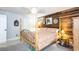 Cozy main bedroom featuring a wood paneled wall, four-poster bed, and carpeted flooring at 5177 Chesapeake Ave, Orlando, FL 32808