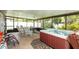 Relaxing sunroom with a hot tub, tile floors, screened windows and multiple rocking chairs, perfect for enjoying the outdoors at 5177 Chesapeake Ave, Orlando, FL 32808