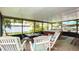 Inviting sunroom with a hot tub, tile floors, screened windows, patio furniture, and lovely views of the landscaped backyard at 5177 Chesapeake Ave, Orlando, FL 32808