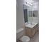 Clean bathroom featuring a toilet, single vanity, and a large mirror above the sink at 5459 Vineland Rd # 4310, Orlando, FL 32811