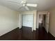 Bright bedroom with hardwood floors, ceiling fan, and closet with shelving at 5459 Vineland Rd # 4310, Orlando, FL 32811