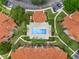 Aerial view of the community swimming pool, landscaped grounds and red tiled roofs at 5512 Metrowest Blvd # 201, Orlando, FL 32811