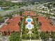 Stunning aerial view of complex with manicured landscaping, pools, and red tile roofs near shopping and recreation at 5512 Metrowest Blvd # 201, Orlando, FL 32811