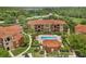 Aerial view of community featuring pool, clubhouse and townhomes with mature palms at 5512 Metrowest Blvd # 201, Orlando, FL 32811