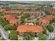 Aerial view of community featuring townhomes, a central lake, lush landscaping and community pool at 5512 Metrowest Blvd # 201, Orlando, FL 32811