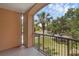Relaxing balcony with metal railing and views of palm trees and lush landscaping, perfect for outdoor enjoyment at 5512 Metrowest Blvd # 201, Orlando, FL 32811