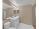 Bathroom features a double sink vanity, a large mirror, and white tiled floor at 5512 Metrowest Blvd # 201, Orlando, FL 32811