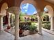 Beautiful courtyard view with lush landscaping, stone columns and arches, creating an inviting outdoor space at 5512 Metrowest Blvd # 201, Orlando, FL 32811