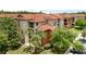 Multi-story condo building showcasing a red tile roof and neutral-toned exterior with surrounding mature trees at 5512 Metrowest Blvd # 201, Orlando, FL 32811