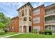 Attractive condo building featuring Mediterranean-style architecture, lush landscaping, and a well-maintained lawn at 5512 Metrowest Blvd # 201, Orlando, FL 32811