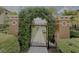 Entrance gate featuring decorative pillars and an archway covered in lush greenery at 5512 Metrowest Blvd # 201, Orlando, FL 32811