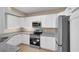 Modern kitchen with white cabinets, granite countertops, and stainless steel appliances, offering style and functionality at 5512 Metrowest Blvd # 201, Orlando, FL 32811