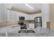 Well-equipped kitchen with white cabinets, modern appliances, granite countertops, and a stylish breakfast bar at 5512 Metrowest Blvd # 201, Orlando, FL 32811