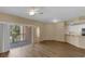 Open-concept living area with wood floors, a balcony, and an open kitchen at 5512 Metrowest Blvd # 201, Orlando, FL 32811