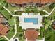 Aerial view of the community pool and clubhouse surrounded by lush landscaping and walkways between buildings at 5512 Metrowest Blvd # 201, Orlando, FL 32811