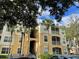 Exterior view of a multi-story condo building with balconies and palm trees at 6100 Stevenson Dr # 207, Orlando, FL 32835