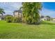 Exterior view of a home featuring a sprawling backyard with lush green grass, mature trees, and a side view of the lanai at 742 Seneca Trl, St Cloud, FL 34772