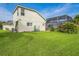 Exterior view of the home featuring a spacious backyard with lush green grass, an enclosed lanai, and a well-maintained lawn at 742 Seneca Trl, St Cloud, FL 34772