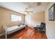 Spare bedroom with hardwood floors, window, ceiling fan, a daybed, and sitting chair at 742 Seneca Trl, St Cloud, FL 34772