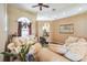 Bright living room with large window, ceiling fan, and elegant furnishings at 742 Seneca Trl, St Cloud, FL 34772