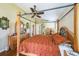 Cozy bedroom featuring a four-poster bed, ceiling fan, and hardwood floors at 742 Seneca Trl, St Cloud, FL 34772
