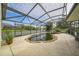A tranquil view of a kidney shaped pool surrounded by stone and enclosed within a screened lanai at 742 Seneca Trl, St Cloud, FL 34772