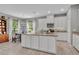 Bright kitchen with white cabinets, granite countertops and a view to the dining area with a decorative chandelier at 7834 Minutemen Loop, Winter Garden, FL 34787
